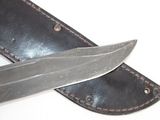 a knife that is laying on top of a leather case