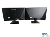 two computer monitors sitting side by side on a white surface