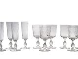 six verres à vin transparents alignés sur une surface blanche