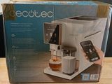 packaging of a coffee machine sitting on top of a wooden table next to a cup of coffee