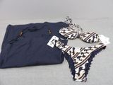 two pieces of clothing are laying on a bed next to each other
