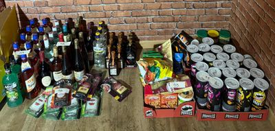 Des bouteilles et des canettes de bière sont par terre, près d'un mur de briques