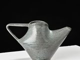 a gray vase that is sitting on a white table