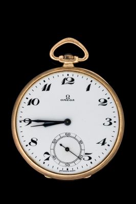 gros plan d'une montre de poche en or sur fond noir