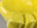 un gros plan d'un bol jaune posé sur une table