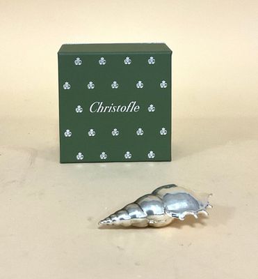 un bibelot en argent posé à côté d'une boîte verte