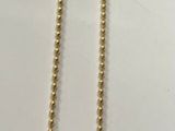 Collier plaqué or avec un pendentif en forme de cœur sur fond blanc