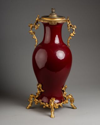 a large red vase with gold decoration on it