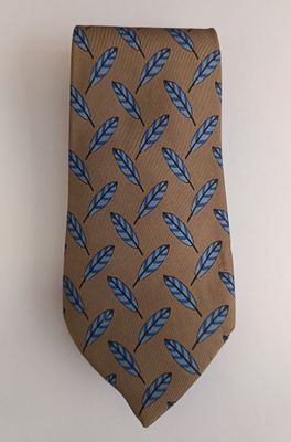 brown necktie with blue feathers on it against a white wall