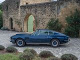 a blue car that is parked in front of a stone building