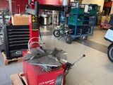 a man that is standing next to a motorcycle in a shop