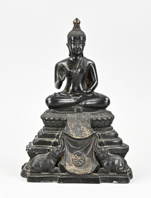 une statue en bronze représentant un Bouddha assis sur un socle