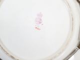 a white plate with a flower on it on a table