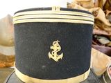 a black hat with a gold anchor on it