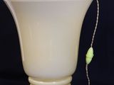 yellow glass vase with a bead hanging from the bottom of it