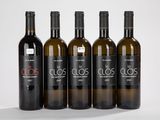 quatre bouteilles de vin sont alignées sur une surface blanche