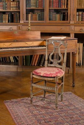 un piano et une chaise dans une pièce avec des bibliothèques
