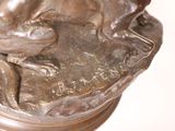 a bronze statue of a dog sitting on a pedestal