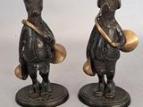 two figurines of animals that are standing next to each other