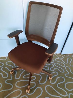 an image of a brown office chair on a rug in a room