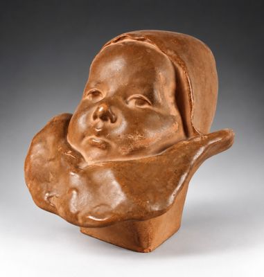 une photo d'une sculpture en argile représentant la tête d'un bébé