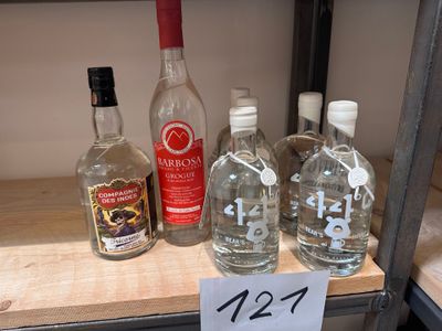 Plusieurs bouteilles d'alcool sont posées sur une étagère dans un magasin