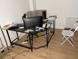 a desk with a computer and a chair in the room