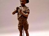 statue en bronze représentant un garçon avec un chapeau et une canne