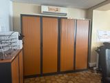a room with a bunch of cabinets and a trash can