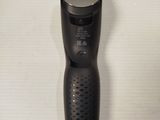 a black shaver sitting on a white surface
