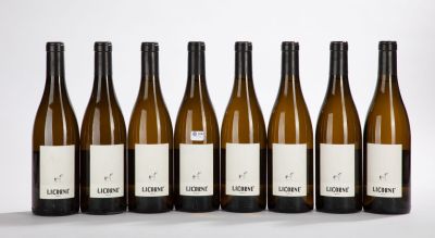 six bottles of wine are lined up in a row on a white surface