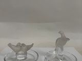 two glass candlesticks sitting on a white table