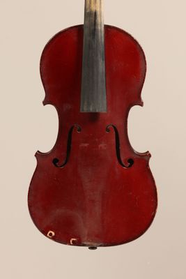 an old red violin sitting on top of a white surface