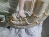 une figurine représentant une femme assise sur un coquillage