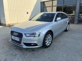 Une Audi argentée est garée devant un immeuble