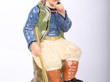 a figurine of a man sitting on a rock talking on a phone