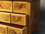 a wooden chest of drawers on a gray surface
