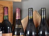 several bottles of wine are lined up in a row on a shelf