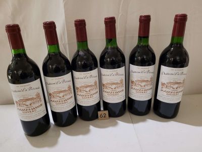 six bottles of red wine are lined up on a table