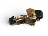 wrist watch with black leather strap and gold buckle on a white surface