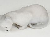 a white cat figurine sitting on a white surface