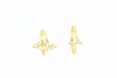 une paire de boucles d'oreilles en or sur fond blanc