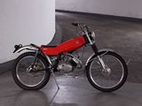 a small red motorcycle parked in a parking garage