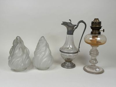 trois vases en verre et une lampe en verre posés sur une surface blanche