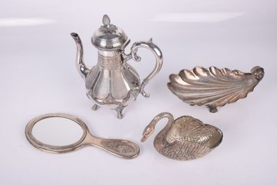 a silver tea pot, spoon, and other items on a white surface