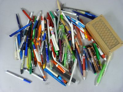 une pile de stylos et de crayons posée sur une table