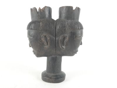 a wooden sculpture of two heads on a white background