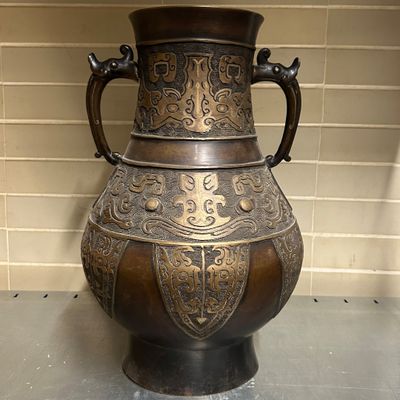 Vase en bronze à patine brune et dorée à décor de symbole As…