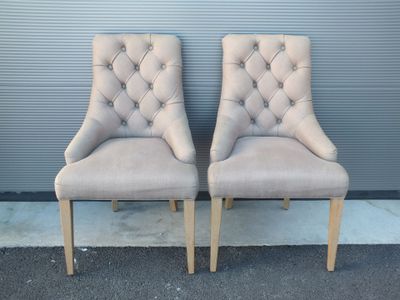 paire de fauteuils rembourrés avec accoudoirs capitonnés