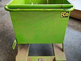 a green bin sitting on a dolly in a warehouse